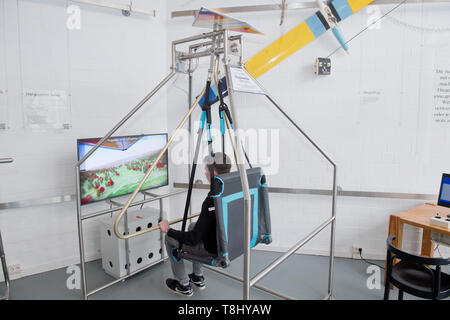 Anklam, Deutschland. 02 Mai, 2019. Lucas Sundt, Mitarbeiter der Otto Lilienthal Museum, fliegt in der Ausstellung des Museums in der neuen mechanischen - virtuelle Hängegleiter Simulator, eine Entwicklung des Museums. Das Otto Lilienthal Museum Anklam und andere Museen in Mecklenburg-vorpommern beteiligen sich am Internationalen Museumstag am 19. Mai. Quelle: Stefan Sauer/dpa-Zentralbild/dpa/Alamy leben Nachrichten Stockfoto