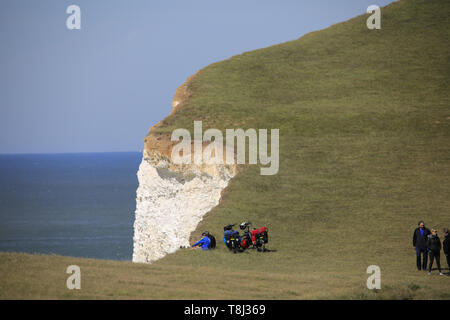 Beachy Head, UK. 14. Mai 2019. Ein paar Radfahrer Posieren für Bilder in der Nähe der Steilküste bei Beachy Head heute. Auch ein Selbstmord Ort bekannt, die Klippen sind Kreide gebildet und sind anfällig für Erosion. Beachy Head, East Sussex, UK. Credit: Ed Brown/Alamy Leben Nachrichten. Stockfoto