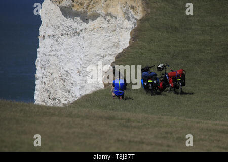 Beachy Head, UK. 14. Mai 2019. Ein paar Radfahrer Posieren für Bilder in der Nähe der Steilküste bei Beachy Head heute. Auch ein Selbstmord Ort bekannt, die Klippen sind Kreide gebildet und sind anfällig für Erosion. Beachy Head, East Sussex, UK. Credit: Ed Brown/Alamy Leben Nachrichten. Stockfoto