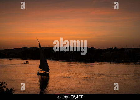 Silhouette einer Feluke Segeln bei Sonnenuntergang, Insel Elephantine, Assuan, Ägypten Stockfoto