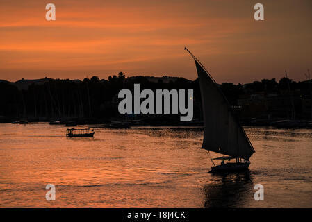 Silhouette einer Feluke Segeln bei Sonnenuntergang, Insel Elephantine, Assuan, Ägypten Stockfoto