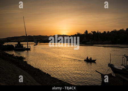 Silhouette der Boote, die am Ufer des Flusses Nil bei Sonnenuntergang, Insel Elephantine, Assuan, Ägypten Stockfoto
