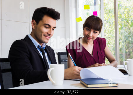 Asian Business Frau und kaukasische Geschäftsmann als Kollegen, Notizen und Schreiben in der Sitzung im Sitzungsraum Stockfoto