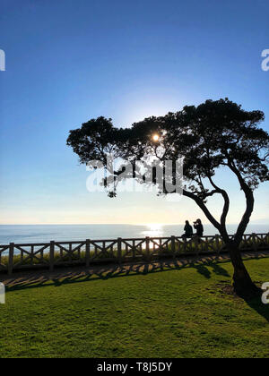 Paar sitzt auf einem Zaun Fotos und ein Blick auf die Ansicht, Santa Monica, California, United States Stockfoto