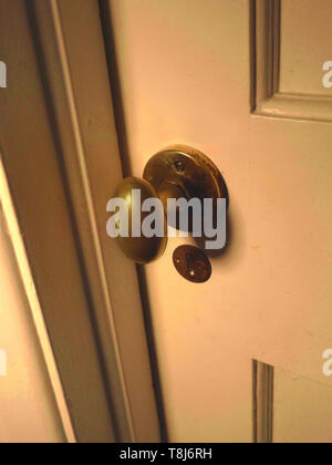 Nahaufnahme eines Messing Türgriff auf eine geschlossene alte Holztür. Stockfoto