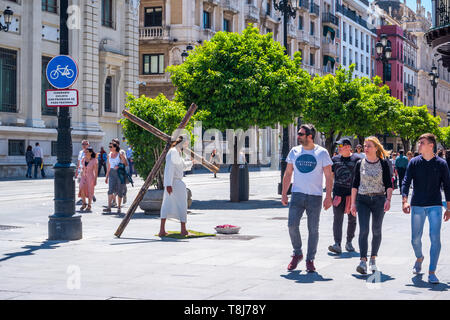 Sevilla, Spanien am 8. Mai 2019 street Schauspieler spielen Jesus Christus große Holzkreuz Stockfoto