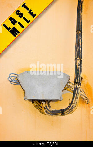 Elektrische Leitungen auf Putz an der Wand mit Schutz Anschlusskasten befestigt - Letzte Meile Konzept Bild Stockfoto