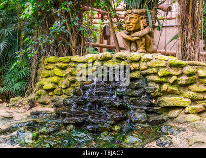 Wasserfall in einem tropischen Garten, streaming Wasser über einige Felsen, Stein Skulptur Dekoration Stockfoto