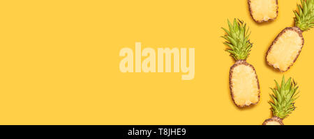 Die Hälfte frisch geschnittene Ananas auf gelbem Hintergrund für minimalen Stil. Stockfoto