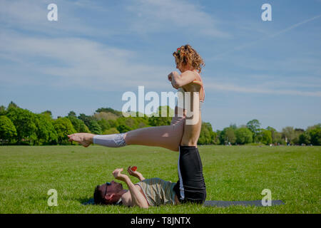 Junge athletische verliebtes Paar Durchführung acro Yoga im Roath Park auf einem hellen, sonnigen Tag. Stockfoto