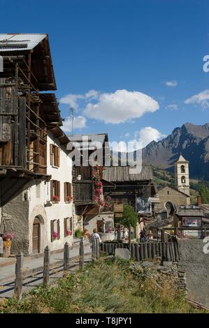 Frankreich, Hautes Alpes, Queyras massiv, Saint Veran, die Hauptstraße mit Holzhäusern gesäumt und der Leiter der Longet (3146 m) Stockfoto