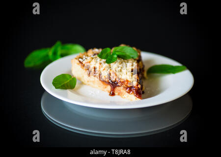 Süße Kuchen mit Früchten Marmelade in eine Platte auf einem schwarzen Stockfoto