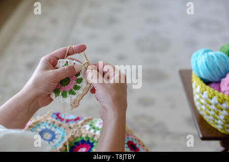 Ältere Frau ist Stricken häkeln. Hobby Handwerk Dinge. Ansicht von oben. Horizontale Zusammensetzung Stockfoto