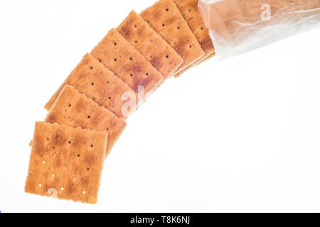 Horizontale Schuß des Ganzen - Weizen Cracker verschütten aus dem Paket. Auf weiß isoliert. Stockfoto