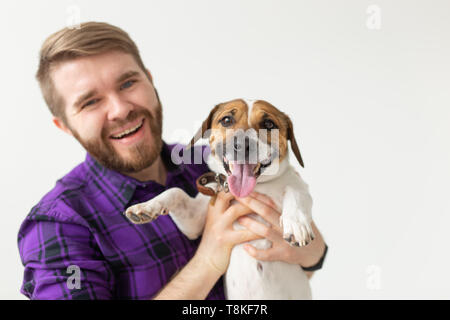 Menschen- und PET-Konzept - glückliche Mann hält einen Hund Jack Russell Terrier über den weißen Hintergrund Stockfoto