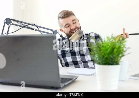 Radio, dj, Blogger und Personen Konzept - junge Mann Moderator Arbeiten am Radio Studio und Sprechen über das Mikrofon Stockfoto