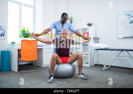 Therapeut seinen Patienten stretching Arme helfen nach Verletzungen Stockfoto