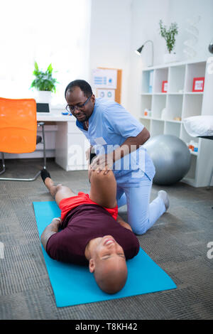 Kahlen junge Sportler mit knieverletzung Sport besuch Therapeuten Stockfoto