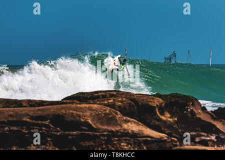 Surfer auf einer Welle eine Manöver zu tun Stockfoto