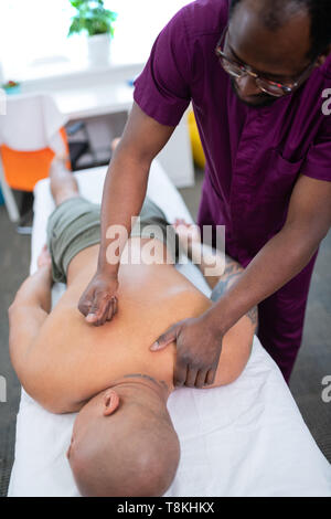 Dunkelhäutige massage Master zurück Massage für Sportler Stockfoto