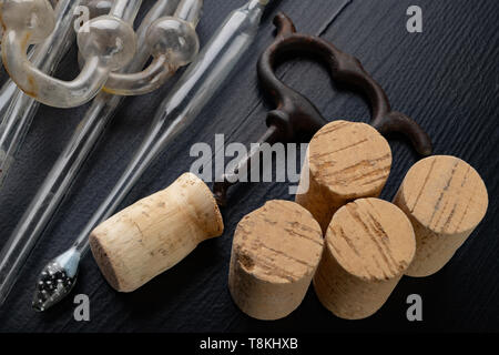 Fermentation Rohr und Korkenzieher auf einem Schwarzen Tisch. Benötigtes Zubehör hausgemachten Wein zu bereiten. Der dunkle Hintergrund. Stockfoto