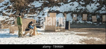 Lehrer und seinem Schüler hatte Gewehr Maschinengewehr Schießen im freien Training am Schießstand. Winter und Schnee kalte Jahreszeit Stockfoto