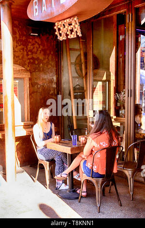 Zwei junge Frauen, die außerhalb der Batch Cafe & Bar auf E-Kongress St in der Innenstadt von Tucson AZ Stockfoto