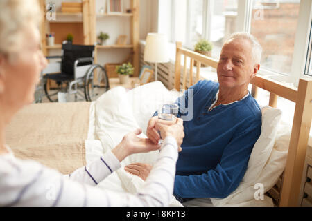 Älterer Mann auf Bettruhe Stockfoto