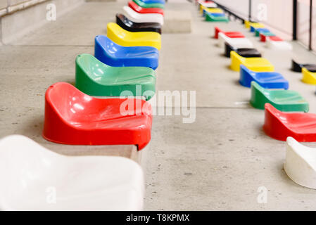 Bunte leere Sitze in den Ständen von einem Stadion. Stockfoto