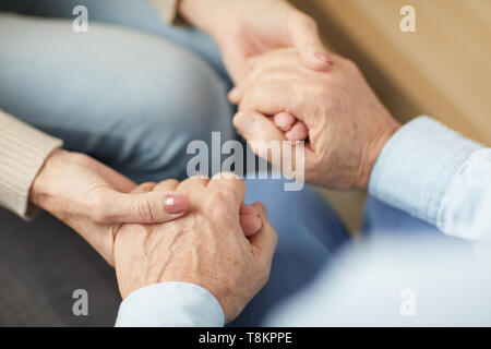 Pflege älterer Paare halten sich an den Händen Stockfoto