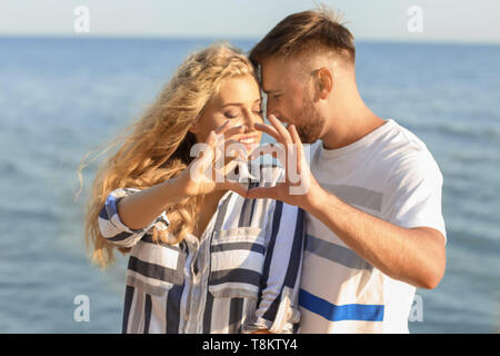 Nettes junges paar Herz, mit der Hand auf das Sea Shore Stockfoto