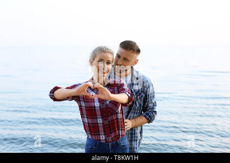 Nettes junges paar Herz, mit der Hand auf das Sea Shore Stockfoto