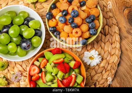 Köstliche Früchte Salate in Schalen auf wicker mat Stockfoto