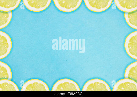 Grenze der Zitronenscheiben auf blauem Hintergrund. Flach Sommer Konzept. Stockfoto