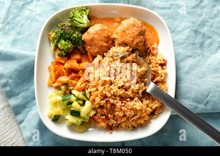 Lecker gekochten Reis mit Frikadellen und Gemüse auf dem Teller Stockfoto
