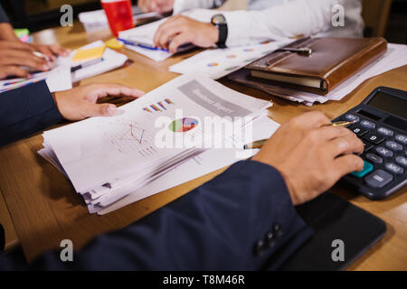 Unternehmer sind mit Taschenrechner und Analyse von Geschäftsdaten und und Grafik Die Grafik in der Sitzung arbeiten. Stockfoto