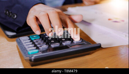 Unternehmer sind mit Taschenrechner und Analyse von Geschäftsdaten und und Grafik Die Grafik in der Sitzung arbeiten. Stockfoto