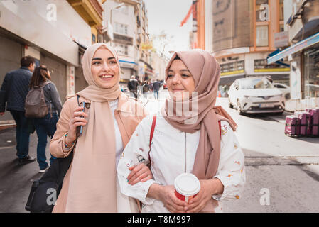 Schöne muslimische Frauen in Kopftuch und modernen trendige Kleidung gehen und miteinander chatten, während Spaß in Istanbul, Türkei. Moderne muslimische wom Stockfoto