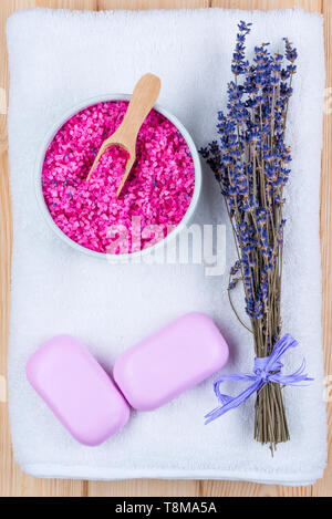 Getrocknetem Lavendel auf einem weißen Frotteehandtuch, Meersalz und zwei Bars von Soap für Spa-Objekte, Ansicht von oben Stockfoto