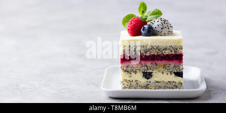 Berry, Mohn geschichteten Kuchen auf weiße Platte. Grauer Hintergrund. Kopieren Sie Platz. Stockfoto