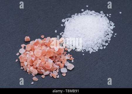 Stapel von grobem Meersalz und Himalaya Pink Salt auf dunklem Hintergrund. Stockfoto