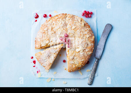 Mandel- und Himbeere Kuchen, Bakewell tart. Traditionelle britische Gebäck. Ansicht von oben. Kopieren Sie Platz. Blauen Hintergrund. Stockfoto