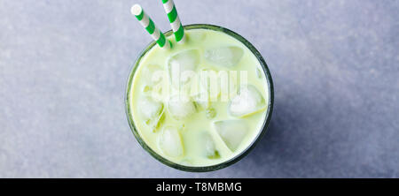 Matcha grüner Tee ice Latte in ein Glas. Grauen Stein Hintergrund. Ansicht von oben. Stockfoto