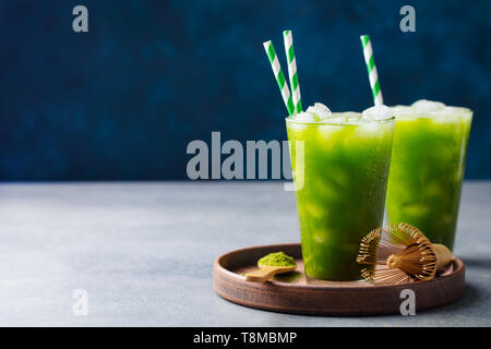 Matcha Eis Kaffee in hohen Glas auf Holzplatte. Blauen Hintergrund. Kopieren Sie Platz. Stockfoto