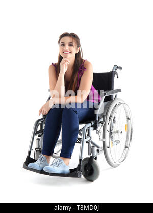 Junge Frau sitzt im Rollstuhl auf weißem Hintergrund Stockfoto