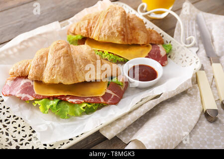 Leckere croissant Sandwiches mit Soße auf Fach Stockfoto