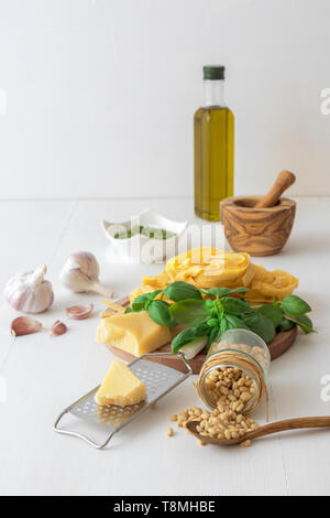 Die Pesto. Die Tabelle mit den zutaten Basilikum Pesto zu produzieren. Mörtel, frisches Basilikum Kräuter, Pinienkernen, Olivenöl, Parmesan, Knoblauch, Schüssel mit p Stockfoto