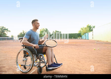 Junger Mann im Rollstuhl spielen Tennis auf Stockfoto