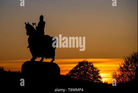 Die Sonne hinter der Statue von Robert the Bruce auf seinem Krieg Pferd in der Schlacht von Bannockburn in der Nähe von Stirling. Stockfoto
