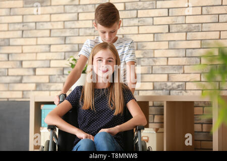 Teenage Mädchen im Rollstuhl und ihrem Bruder zu Hause Stockfoto